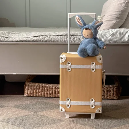 Olli Ella kanin bamse i blød blå dragt siddende på kuffert – tryghedsbamse til baby og børn