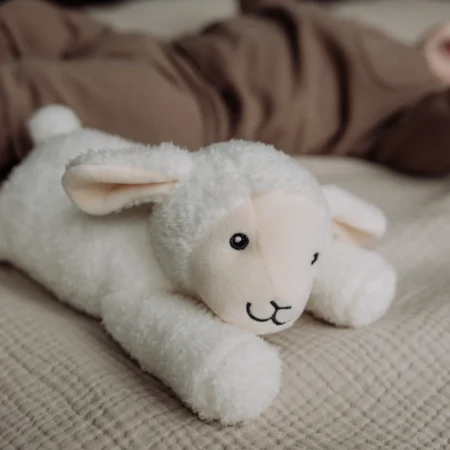Hjertelydsbamse Rosie fra Flow Amsterdam ved siden af sovende baby – beroligende bamse med hjertelyd og white noise