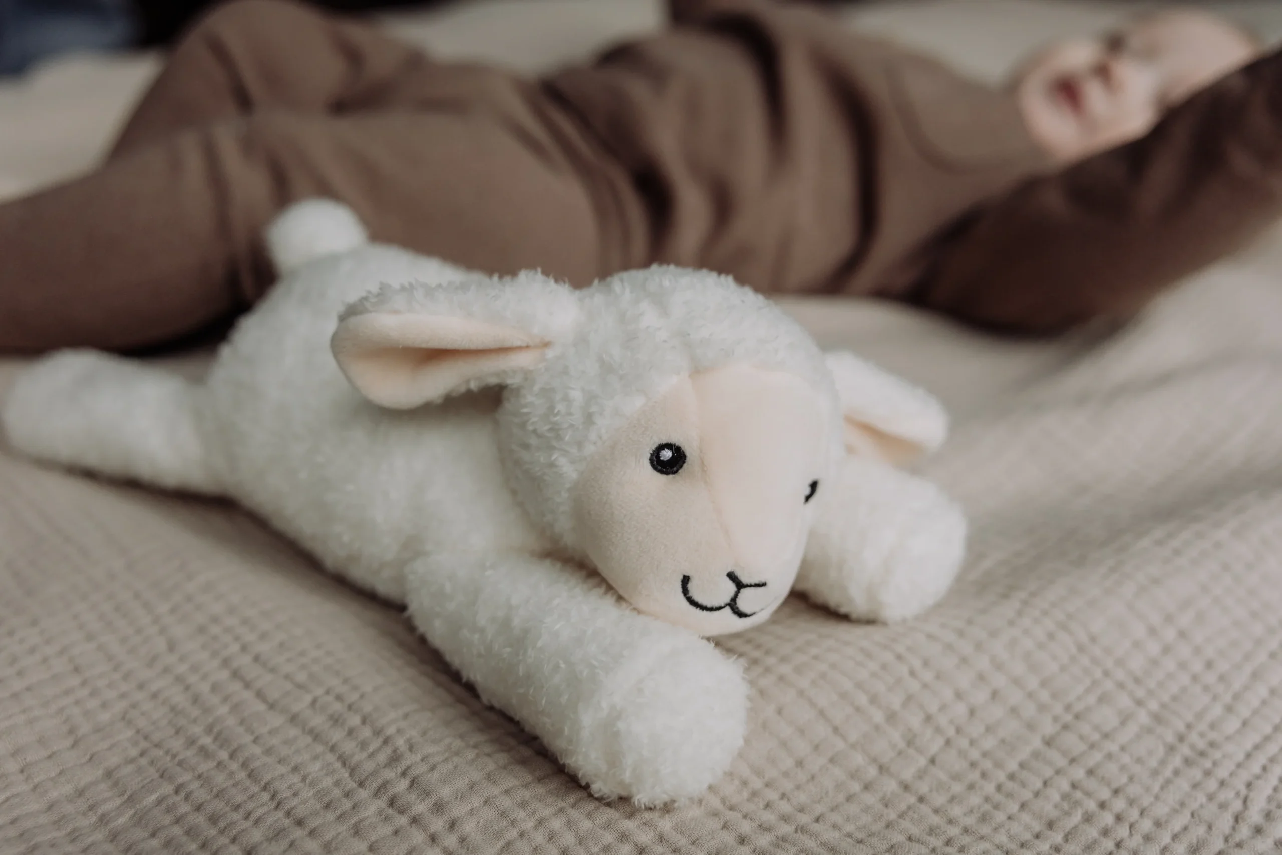 Hjertelydsbamse Rosie fra Flow Amsterdam ved siden af sovende baby – beroligende bamse med hjertelyd og white noise